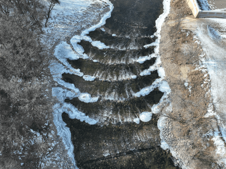 Aerial view of the rock weirs in the Sheyenne River with riverbanks on either side.